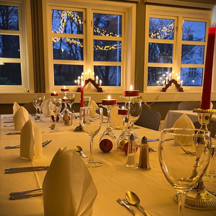 Elev i kvit skjorte som held eit serveringsbrett med glass med appelsindrikke i