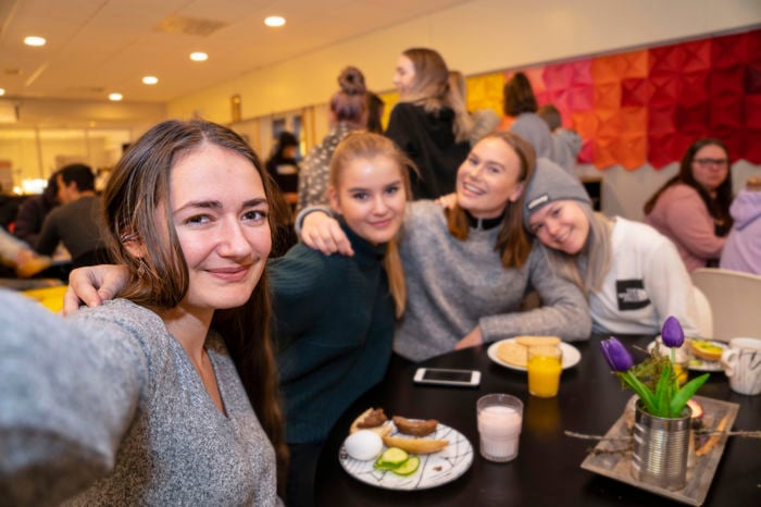 Blide elevar i kantina, alle ser mot kamera