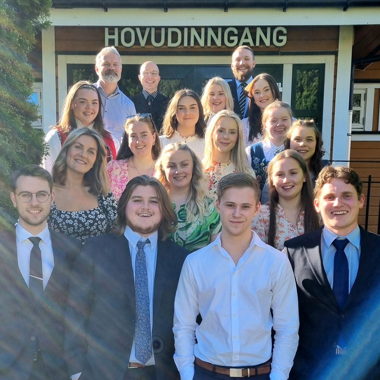 Eit klassebilde av elevar, pynta med dress, kjolar og bunad. Lærarane er og med. 