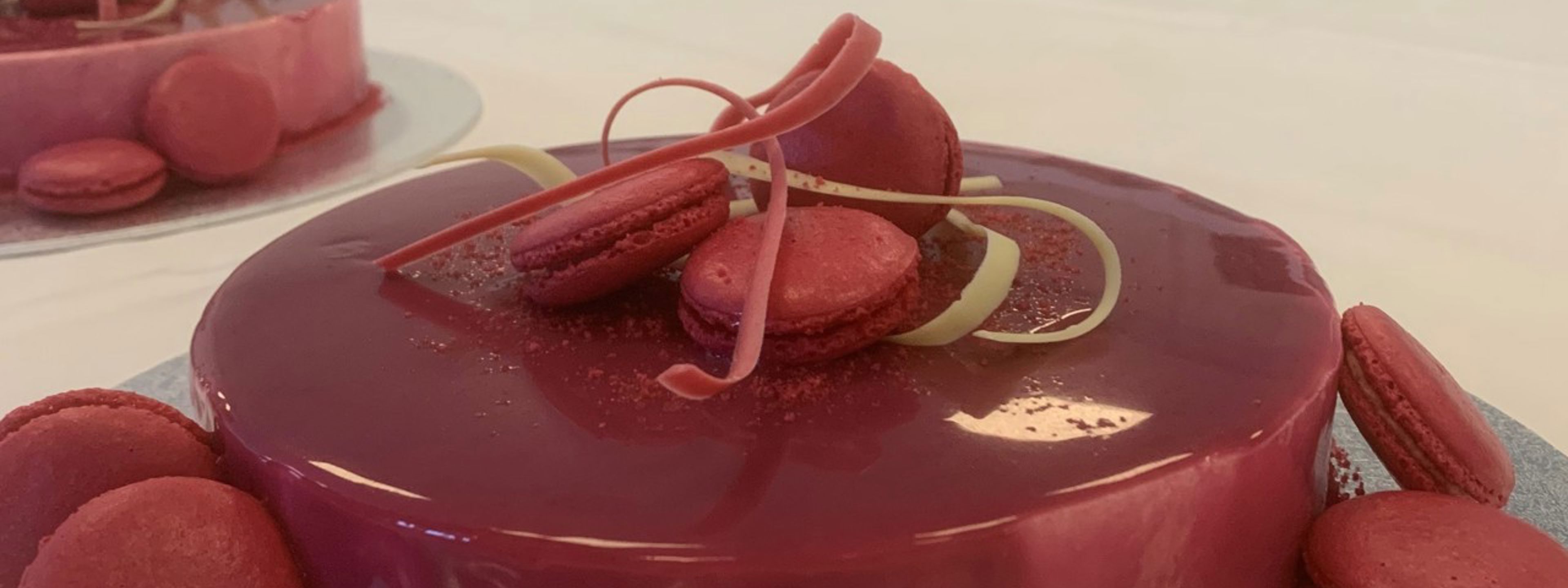 Ei vakkert pynta kake, med raud gele på toppen og raude makroner rundt