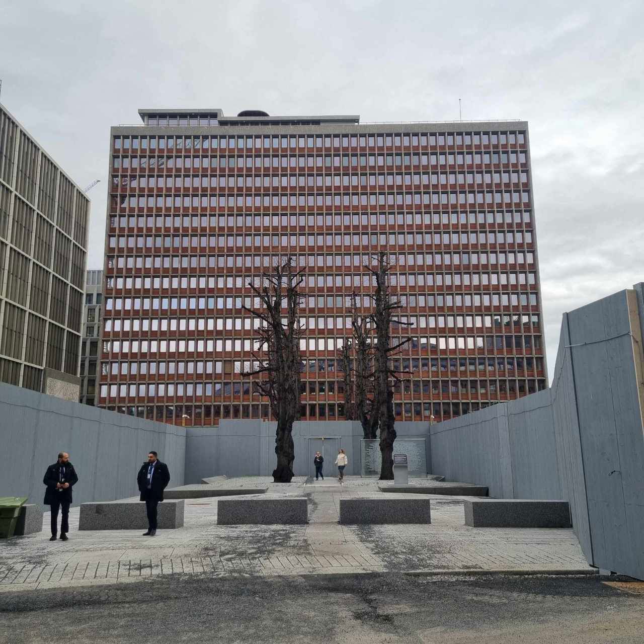 Regjeringsbygget i Oslo og byggeplassen rund. To personer i framgrunnen.