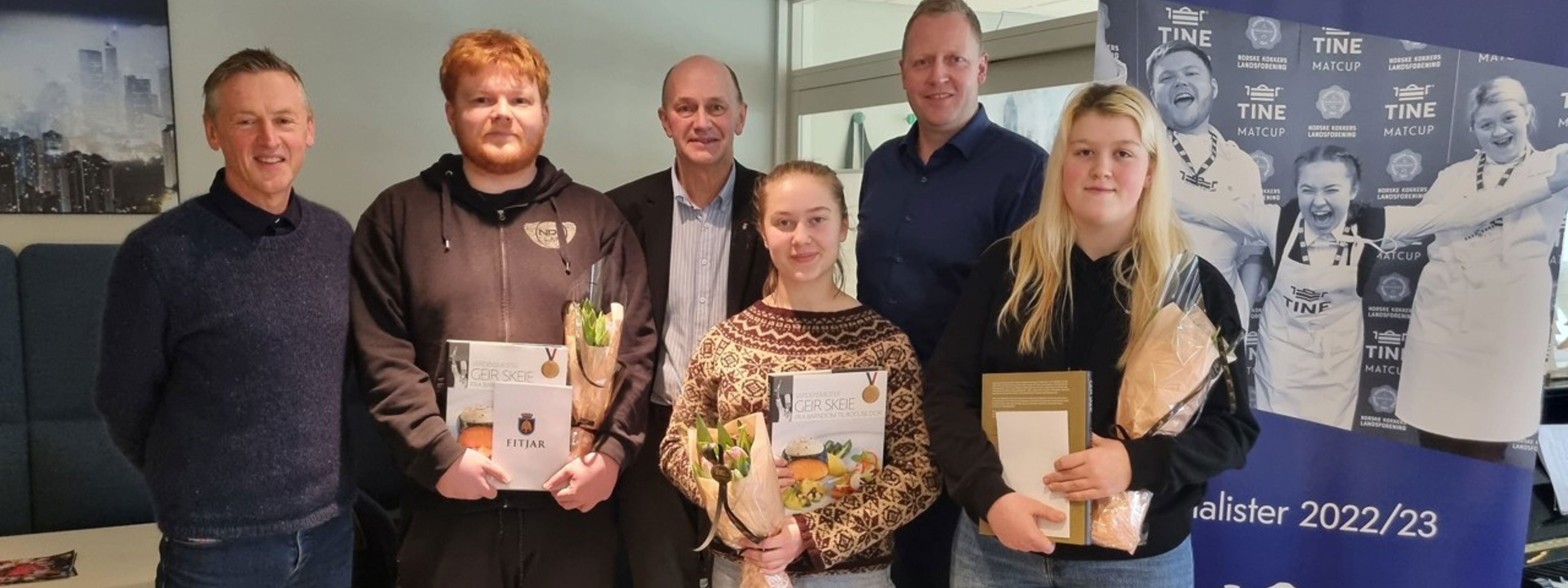 Rektor, ordførar, varaordførar og dei tre elevane står attmed ein banner frå Tine MatCup