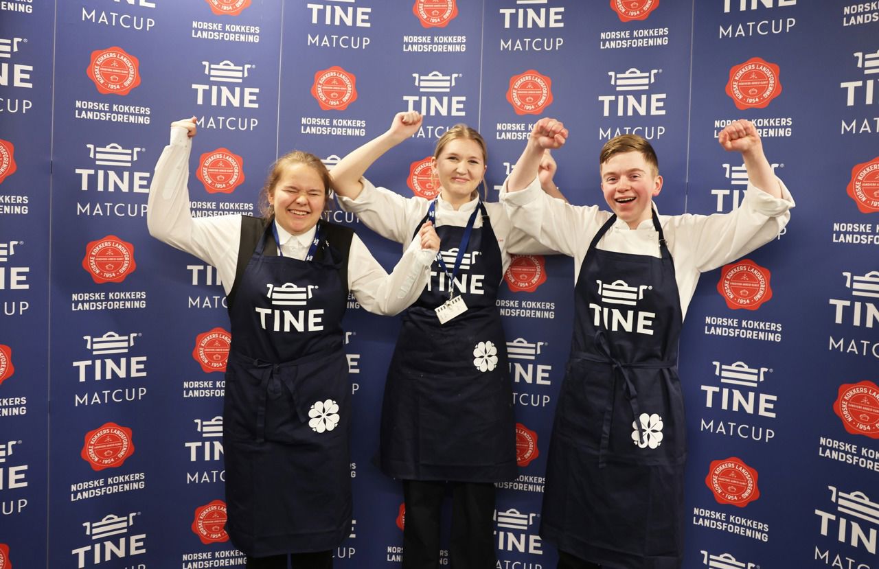 Tre elevar i kokkeklede som jublar for finaleplass framfor eit banner frå Tine MatCup