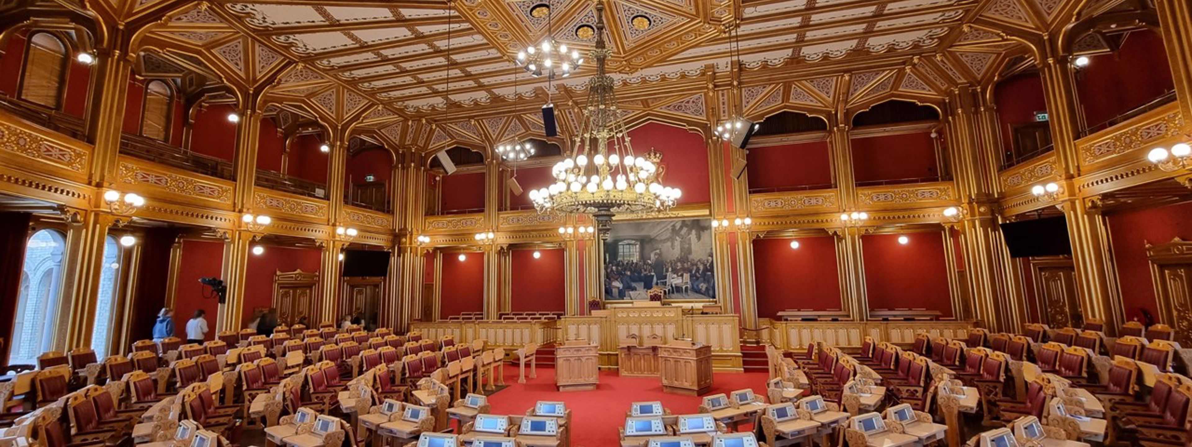 Eit bilde av Stortingsalen i Oslo, frå bak i lokalet, sett mot talarstolen