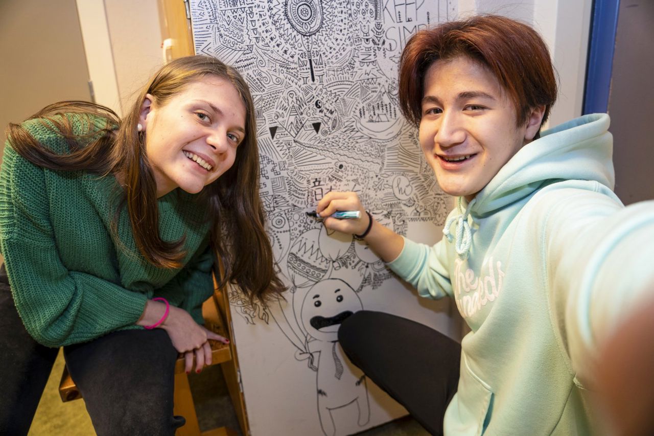 Elevar som teiknar på ein vegg