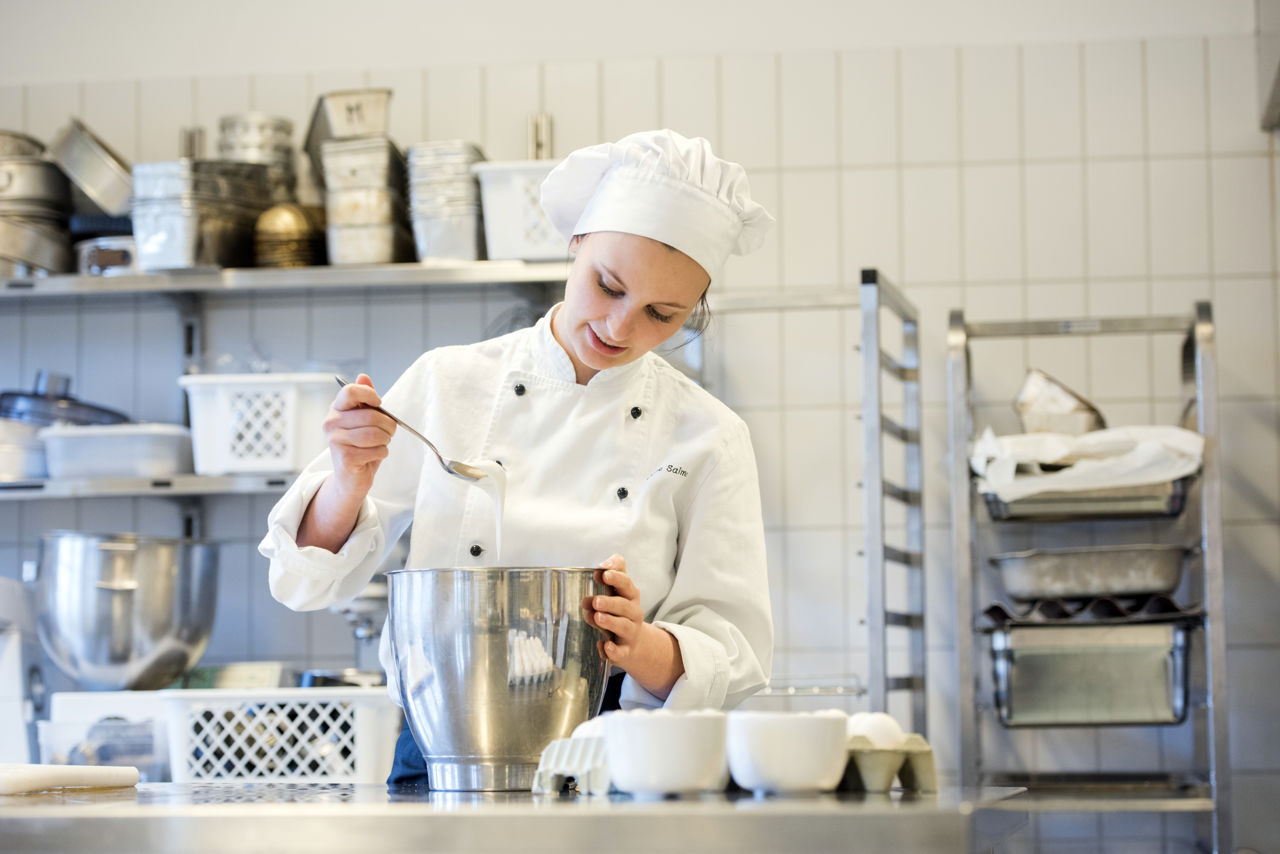 Elev som arbeidar med ein deig i ei bolle